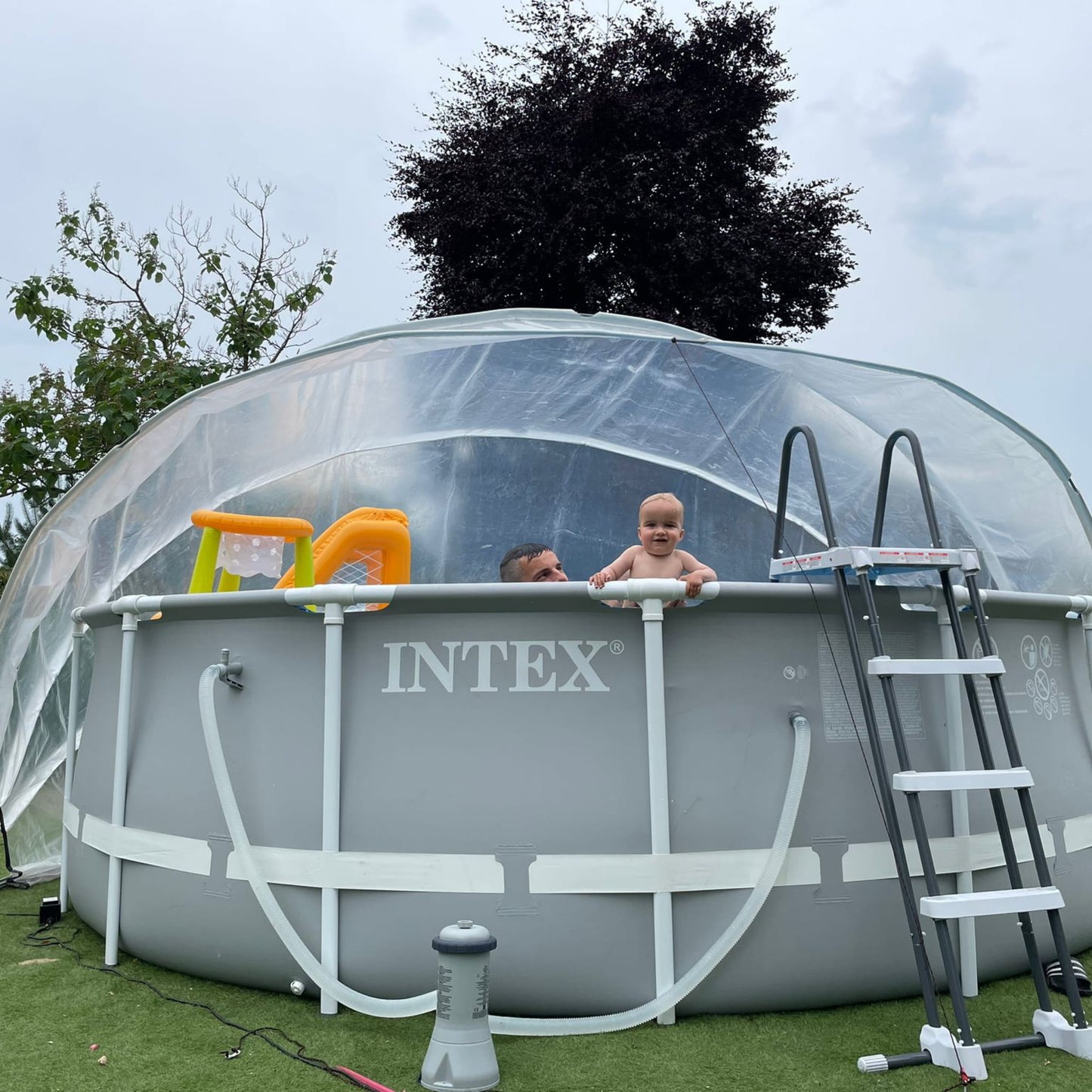 A large round pool dome covering an above-ground pool with a ladder, toys visible inside the pool.