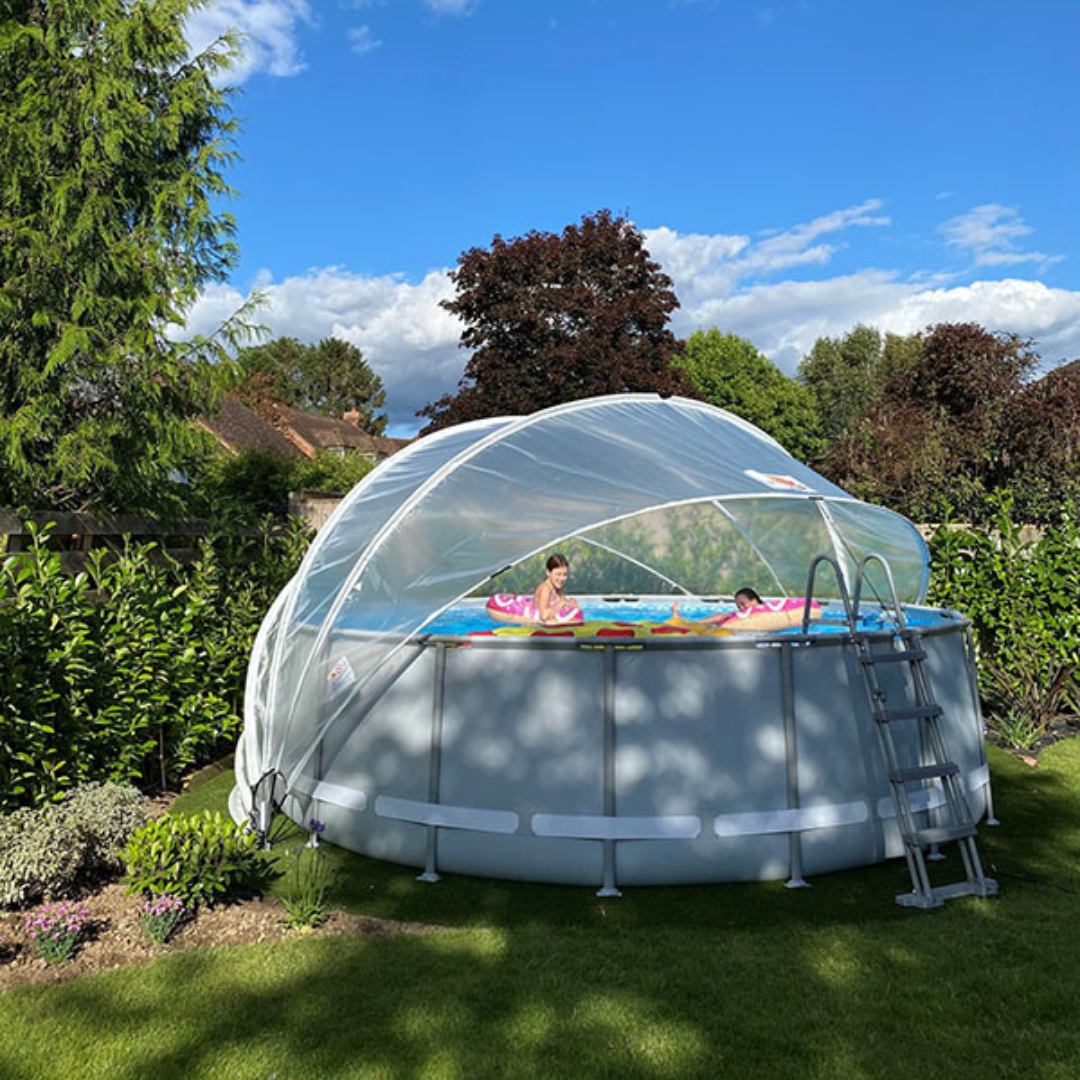 Children playing in a pool with a transparent dome cover on a sunny day.
